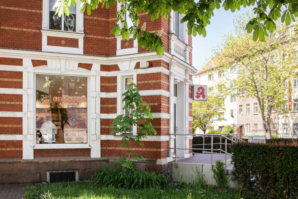 Eingang zur Germania Apotheke mit Schaufenster und rotem Ziegelfassade in Erfurt. In der Germania Apotheke in Erfurt